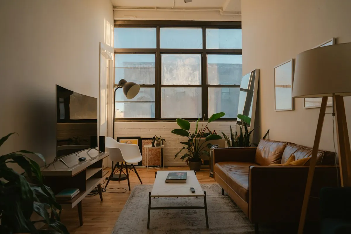 A bright, inviting living room in a modern apartment with cozy furniture and warm lighting.