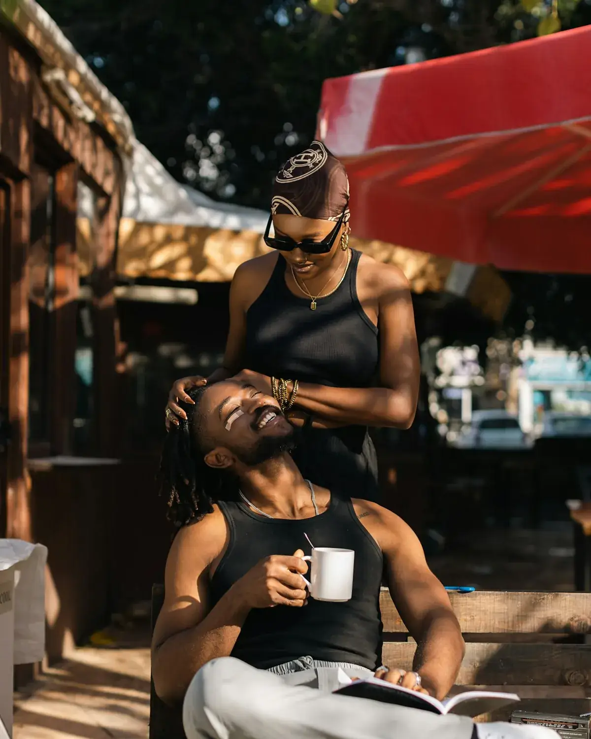 Image of a happy couple enjoying coffee on a sunny apartment balcony.