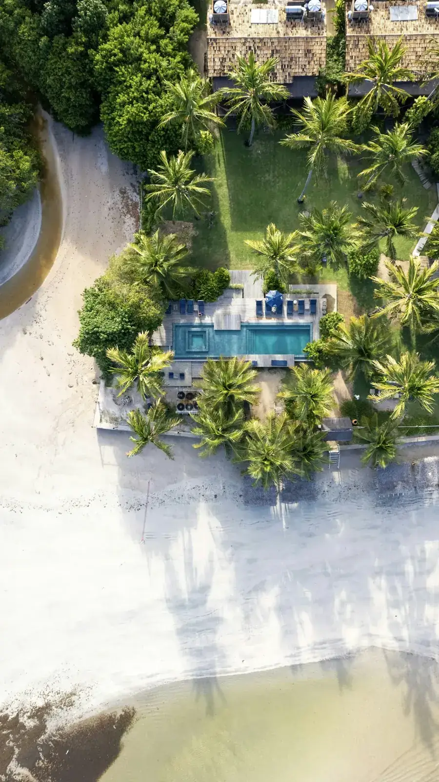 Aerial view of a modern beachfront villa in St. Vincent with lush greenery surrounding it.
